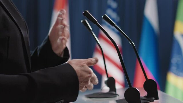 Close-up side view shot footage of hands belonging to Caucasian female politician speaking about global issues during international convention