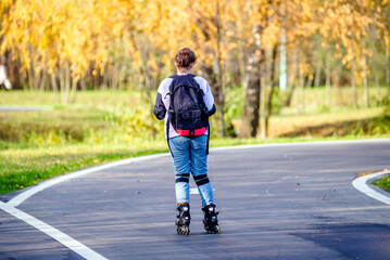 Fototapeta premium Girl roller skating in the autumn Park 