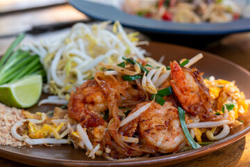 Pad Thai, Traditional stir-fried rice noodle dish commonly served as a street food and at most restaurants in Thailand as part of the country's cuisine. Stir fry noodles with sweet savoury sour sauce.