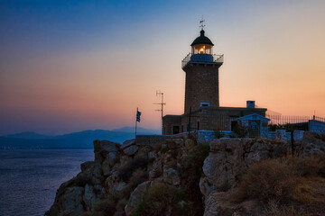 Fototapeta na wymiar Lighthouse on the coast on sunset, Greece coastline
