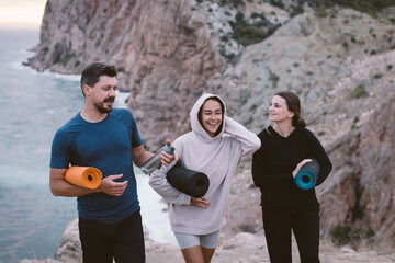 Fototapeta premium Group of young people going home from yoga class outdoors with beautiful sea view.