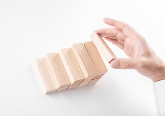 Businessman builds a ladder from wooden blocks. Concept of business growth and success