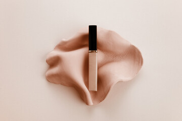 Cosmetic liquid foundation on biege background. Top view