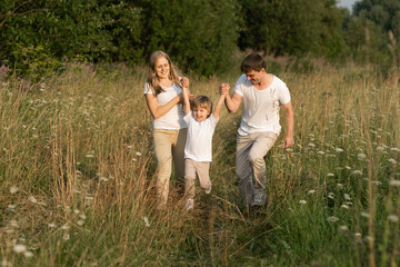 Happy family enjoying walk together at meadow in summer