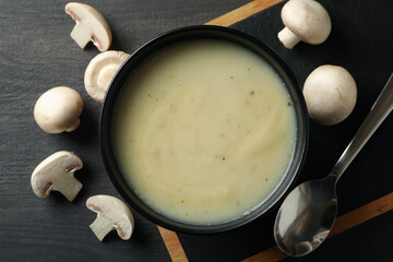 Concept of tasty lunch with bowl of mushroom soup on wooden background