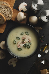 Concept of tasty lunch with bowl of mushroom soup on wooden background