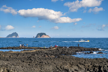 Jeju Island is Korea's leading tourist destination. This is a coastal walkway where you can see two islands. There are haenyeo in the blue sea.
