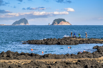 Jeju Island is Korea's leading tourist destination. This is a coastal walkway where you can see two islands. There are haenyeo in the blue sea.