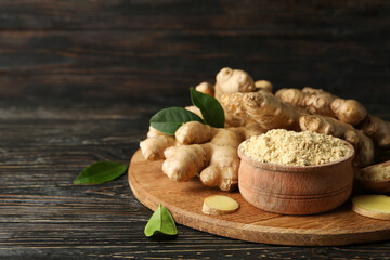 Board with ginger and ginger powder on wooden background