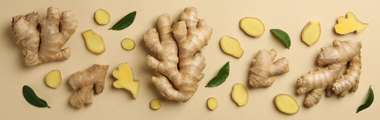 Fresh ginger and leaves on beige background, top view