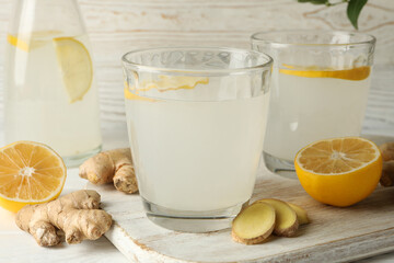 Concept of breakfast with ginger lemon water on white wooden background