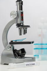 Close-up view of professional microscope for vaccine research on laboratory background. Healthcare and medical concept.