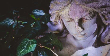 Sad angel in the sunlight as symbol of death and end of human life. Fragment of an ancient stone...
