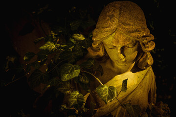 Beautiful sad angel in the sunlight. Fragment of an antique stone statue. Horizontal image.