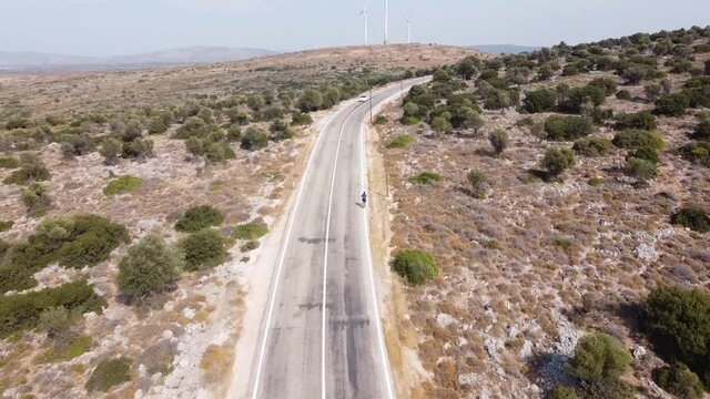 A cyclist is filmed by a drone from a birds eye view against the spectacular backdrop of the Turkish Aegean Sea