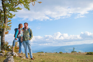 Happy couple hiking and enjoying a valley view