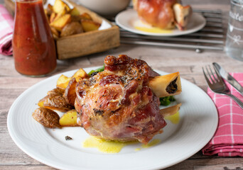 grilled knuckle of pork with potatoes served on a plate