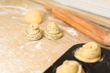 raw cruffins before baking in the oven in an iron mold. puff pastry croissant similar to a muffin rolled into a roll. modern baking. close-up, space for text. horizontal frame