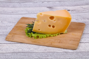 Maasdam cheese  in the board served salad leaves