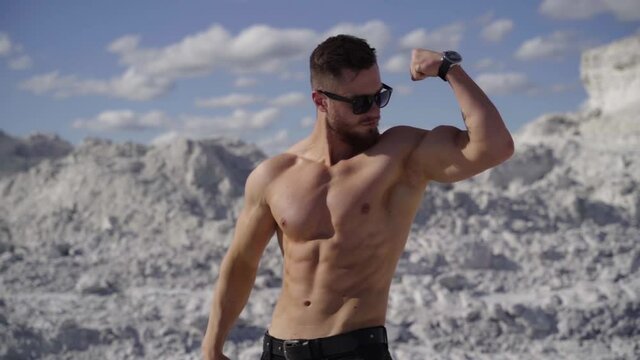 Muscular man posing outdoors. Handsome muscular shirtless hunk man outdoor