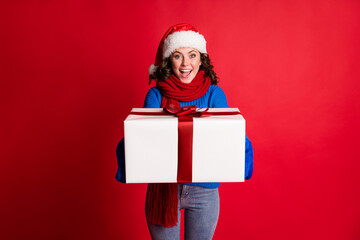Portrait of her she nice attractive cheerful cheery girl wearing festal cloth holding in hands giving delivering you big large giftbox isolated bright vivid shine vibrant red color background