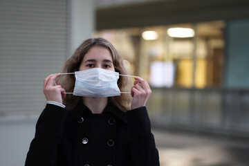 young girl wearing a protective mask from coronavirus
