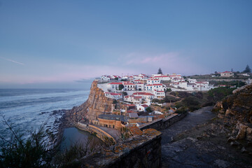 Fototapeta na wymiar View of village and the natural pool of Azenhas do Mar, Colares (Sintra), Portugal. Ocean shore in sunset time.