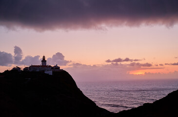 Famous lighthouse on Cabo da Roca, the western point of Europe. Beautiful sunset landscape with ocean shore.
