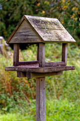Wooden bird house on a wood pole