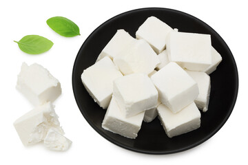 Slices feta cheese with basil in a black plate isolated on white background. Clipping path and full depth of field. Top view