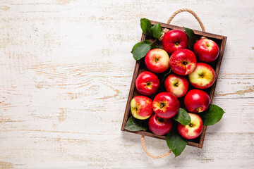 Ripe red apples in wooden box.
