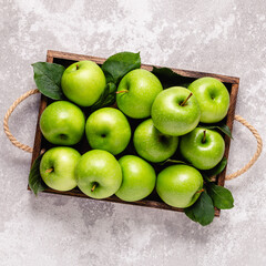 Ripe green apples in wooden box.