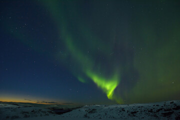 Fototapeta na wymiar Night sky. Northern Lights. Hills in winter in snow.