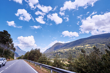 Obraz premium Asphalt road in Alps mountains. Trip concept.