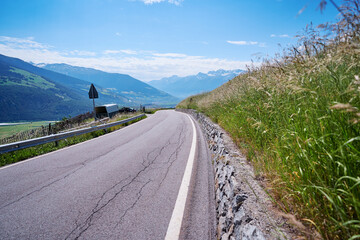 Asphalt road in Alps mountains. Road trip concept.