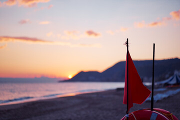 Travel by Turkey. Red flag and safety buoy circe on the sea beach.