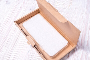 Brown flat cardboard box for cellphone, smartphone case packaging.