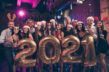 Photo portrait of people celebrating new year 2021 with balloons santa claus reindeer headwear caps