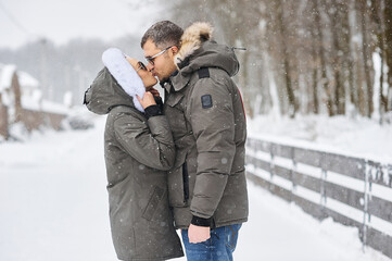 Fototapeta na wymiar A portrait of kissing couple in winter park