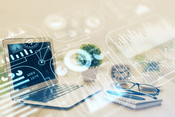 Computer on desktop in office with technology theme hologram. Double exposure. Tech concept.
