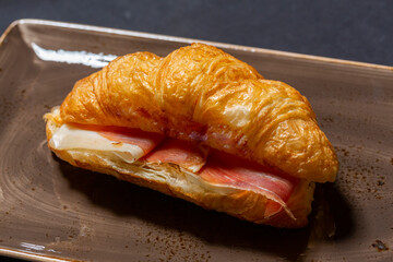 Croissant prosciutto sandwich served on a plate