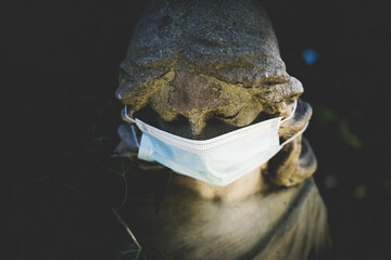 Ancient statue of beautiful angel in medicine respirator mask as symbol of coronavirus, air...
