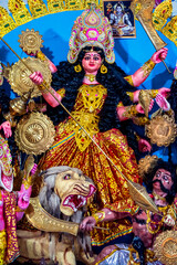 Decorated sculpture of goddess Durga idol on lion with ten arms at pandal and temple in colored light. Durga Puja is big cultural Hindu religious festival in west Bengal, India. Navaratri background.