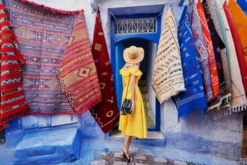  Colorful traveling by Morocco. Young woman in yellow dress walking in  medina of  blue city Chefchaouen. © luengo_ua