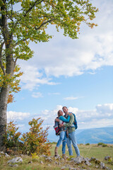 Fototapeta na wymiar Happy couple hiking and enjoying a valley view and hugging