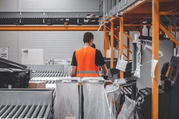 Fototapeta na wymiar A man working at a conveyor belt in a sorting office