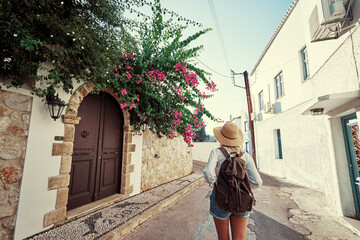 Fototapeta na wymiar Enjoying vacation in Greece. Young traveling woman walking on Greek Old Town.