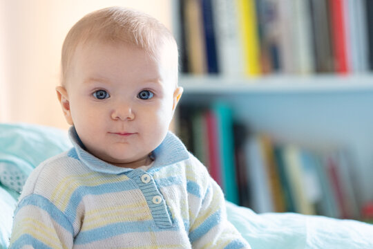 Neonata felice sveglia di 5 mesi in pannolino sdraiato e giocando