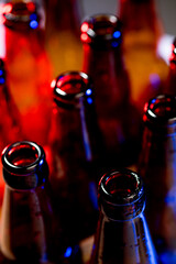 Dark. Neon colored beer bottles, close up isolated on bright studio background. Concept of beer,...