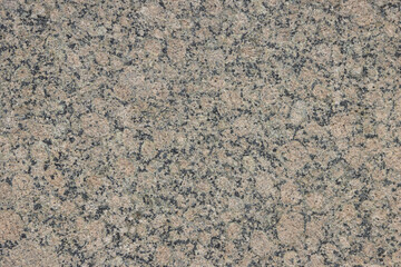 The texture of a variegated speckled polished marble slab.